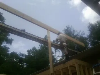 Carpenter setting a ridge beam over a new addition frame — Ice Dam Removal by Roofing Brothers in Brainard