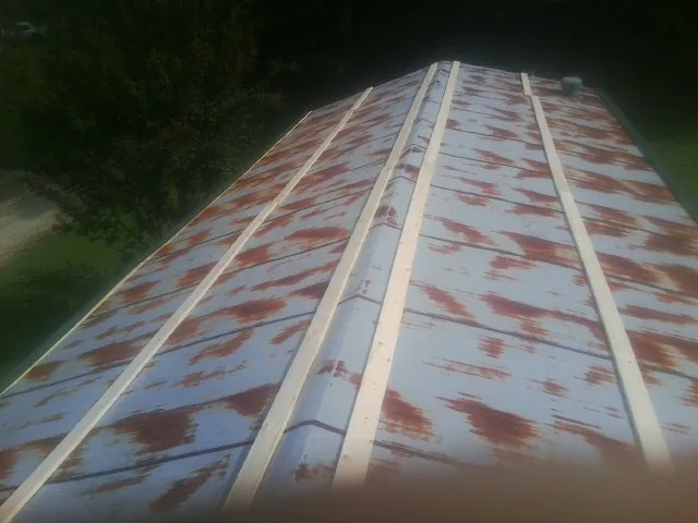 Rusted metal roof panels with new wood purlins before replacement — Storm Damage Roof Repair in Brainard by Roofing Brothers