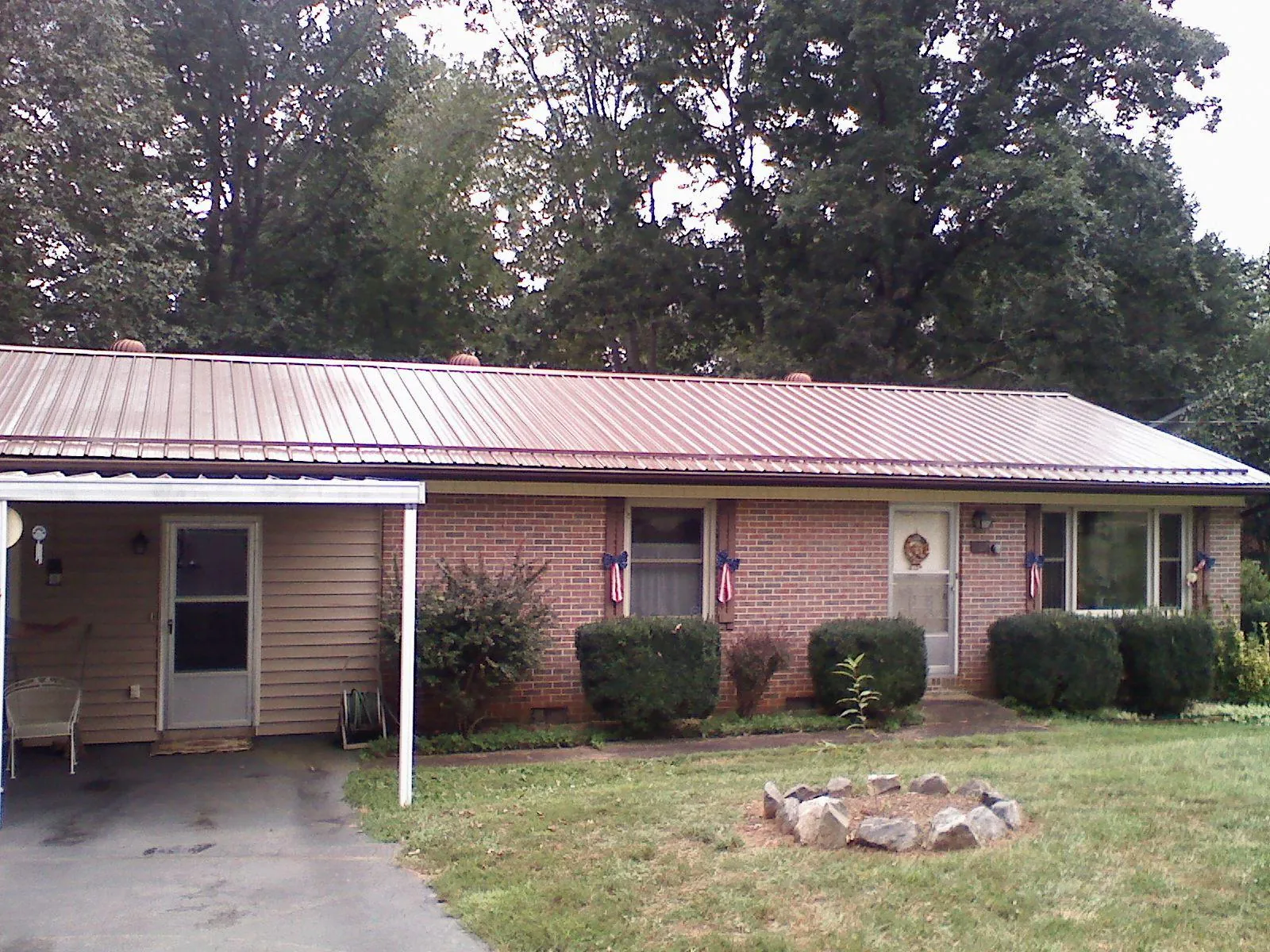 Bronze metal roof and carport on a brick ranch home — Roof Repair work by our crew in Brainard